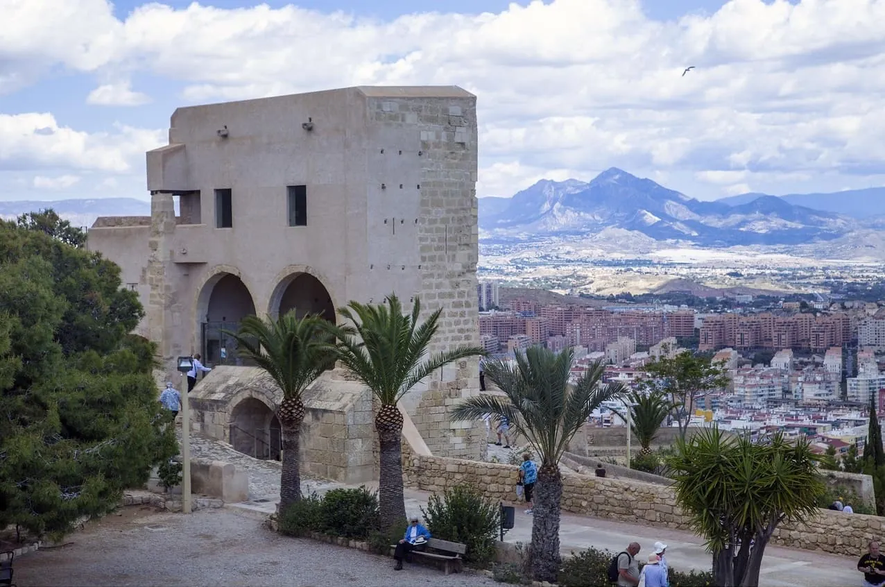 Santa Barbara vár Alicante legfontosabb látnivalói között , régi arab tornyok előtti udvar pálmafákkal